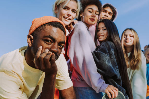 A group of six generation Z type students. standing all together outside. 